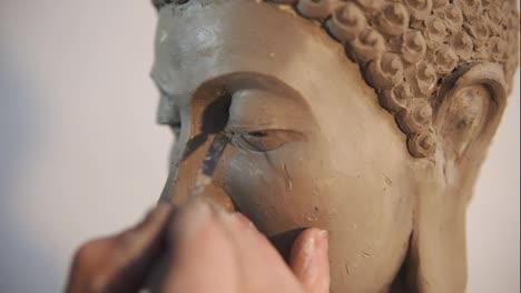 Porträt-Des-Gesichtes-Der-Buddha-Statue-Aus-Ton,-Künstler-Arbeitet-Mit-Details-Mit-Spachtel