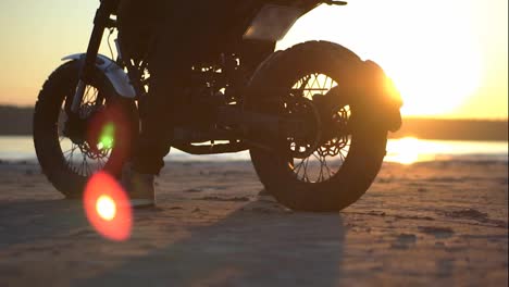 Footage-of-bike's-wheels-with-biker-on-it-against-sunset-under-water