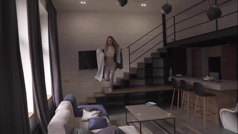 Relaxed-woman-in-pajamas-and-plaid-jumping-on-a-couch-running-from-the-stairs-at-home