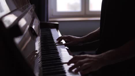 Closeup-of-male's-hands-practicing-to-play-the-piano-at-home