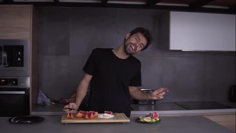 Funny-man-cooking-vegetarian-breakfast-at-kitchen-at-home-while-dancing-and-singing