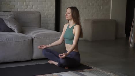 Frau-In-Sportkleidung-Macht-Yoga-Übungen,-Sitzt-Auf-Dem-Boden-Im-Lotussitz-Und-Praktiziert-Yoga