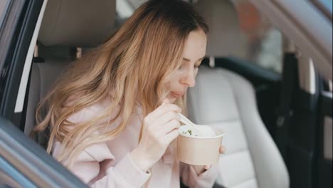 Woman-eating-soup-inside-the-parked-car
