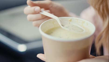 Woman-eating-cream-soup-inside-the-parked-car