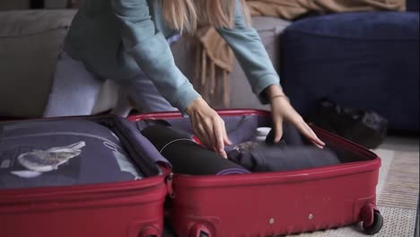 Unrecognizable-woman-in-a-hotel-room-puts-things-in-a-suitcase,-closeup
