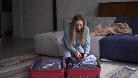 Woman-folding-suitcase,-getting-ready-for-road-trip-preparing,-luggage-for-vacation