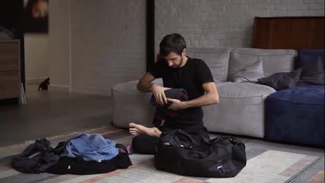 A-man-packing-a-suitcase-or-luggage-for-travel-in-living-room