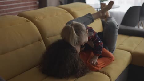 Mother-and-small-child-preschool-girl-enjoying-bonding-having-fun-on-couch