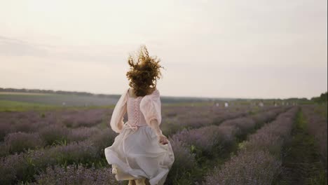 Beautiful-woman-with-a-pink-dress-running-joyfully-through-a-lavender-field