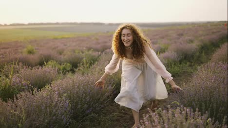 Woman-with-a-pink-dress-running-joyfully-through-a-lavender-field-and-smiling