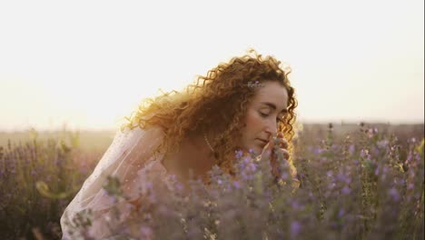 A-woman-with-curly-hair-observes-the-beauty-of-a-lavender-field-in-bloom