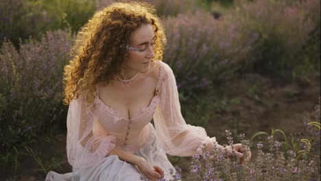 A-woman-with-curly-hair-observes-the-beauty-of-a-lavender-field-in-bloom,-slowmo