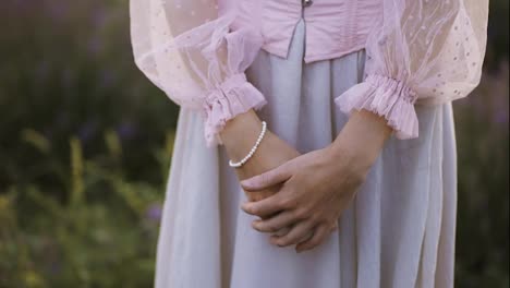 Shy-woman-in-beautiful-pink-dress,-close-up-of-hand