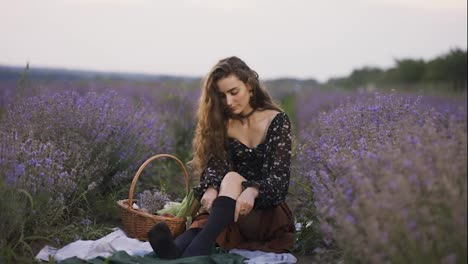 Sensual-woman-on-lavender-field,-putting-on-black-tights,-slow-motion