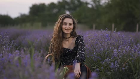 Lovely-young-woman-wearing-stylish-dress-and-sitting-in-purple-lavender-field