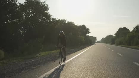 Ein-Männlicher-Radfahrer-Mit-Helm-Fährt-Mit-Dem-Fahrrad-Auf-Einer-Leeren-Strecke