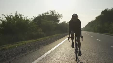 Un-Ciclista-Con-Casco-Monta-En-Bicicleta-Por-Una-Pista-Vacía,-Vista-Frontal