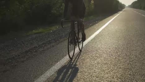 Vista-Recortada-De-Un-Ciclista-Masculino-Anda-En-Bicicleta-Por-Una-Pista-Vacía