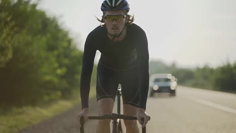 Männlicher-Radfahrer-Mit-Helm-Fährt-Fahrrad-Entlang-Der-Strecke-Und-Gewinnt-An-Geschwindigkeit