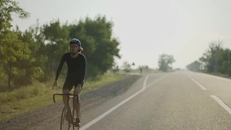 Un-Ciclista-Con-Casco-Monta-En-Bicicleta-Mientras-Estira-Las-Manos.