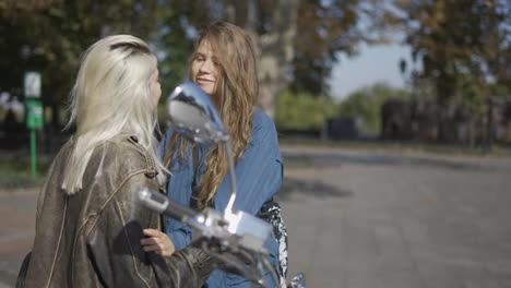 Two-young-women-kissing-mounted-on-the-motorcycle-in-the-city