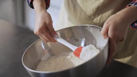 Unrecognizable-girl-in-apron-mixing-ingredients-for-pastry