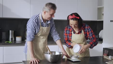 Couple-cooking-together,-woman-measuring-sugar-portion