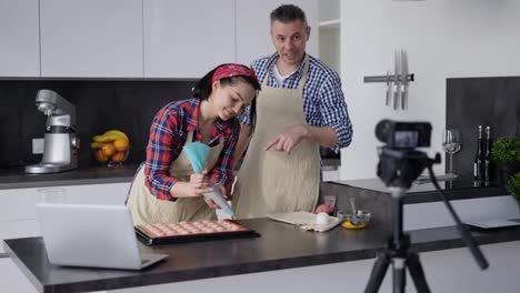 Videostream-Eines-Positiven-Paares-In-Der-Küche,-Das-Zu-Hause-Makronen-Zubereitet