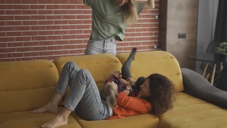 Mothers-are-playing-with-blondy-small-girl-in-the-living-room