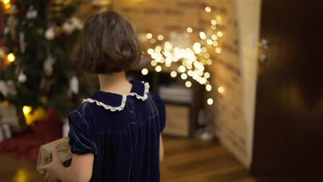 Glückliches-Mädchen,-Das-Eine-Geschenkbox-Unter-Den-Geschmückten-Weihnachtsbaum-Stellt