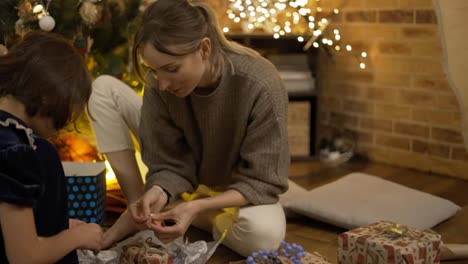 Mother-and-daughter-wrapping-creative-Christmas-presents-together,-close-up