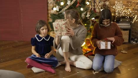 Mother-giving-her-daughters-their-Christmas-gifts