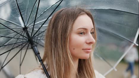 Schöne-Frau-Mit-Transparentem-Regenschirm-An-Einem-Regnerischen-Tag
