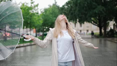 Carefree-young-blonde-woman-lets-the-refreshing-spring-rain-fall-down-on-her