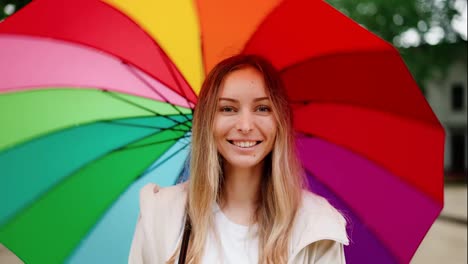 Kaukasische-Frau-Dreht-Bunten-Regenschirm-Und-Lächelt