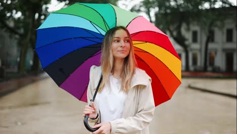 Portrait-of-a-woman-spinning-multi-colored-umbrella-on-the-street