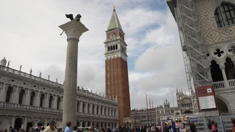 Looking-Past-Colonna-di-San-Marco-With-View-Of-Biblioteca-Nazionale-Marciana-And-St-Mark's-Campanile-In-Background-At-San-Marco-Square-In-Venice