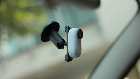 Insta360-Go-Action-Kamera-An-Der-Windschutzscheibe-Eines-Autos-Befestigt-Und-Von-Hand-Abgenommen