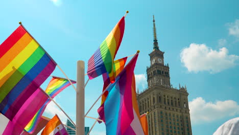 Colorful-pride-flags-waving-in-breeze-with-palace-of-culture-and-science-in-back