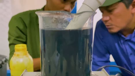 2-men-are-doing-an-experiment-with-a-black-chemical-liquid