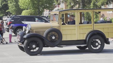 Old-mustard-station-wagon-at-parade-with-people
