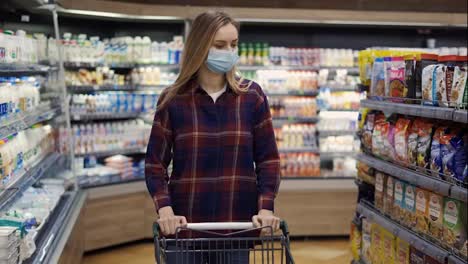 Young-woman-carries-a-cart-in-the-supermarket-during-the-quarantine-period