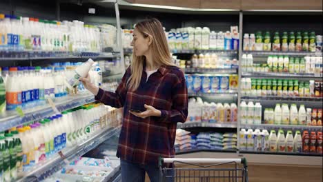 Frau-Kauft-Im-Supermarkt-Mit-Smartphone-Ein-Und-überprüft-Die-Einkaufsliste