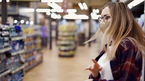 Happy-young-woman-in-mask-dances-in-supermarket,-having-fun