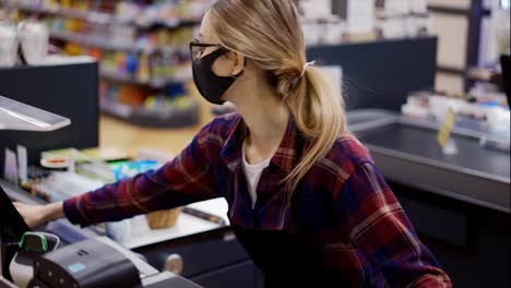 Female-cashier-in-a-protective-mask-pierces-the-products-with-the-scanner-in-slow-motion
