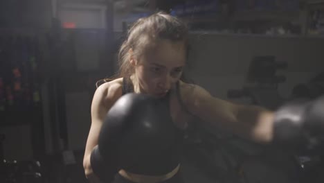 Boxerin-Schlägt-Während-Des-Trainings-In-Handschuhen-In-Die-Kamera