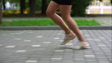 Close-Up-of-female-athlete's-feet-running-at-the-park.-Fitness-woman-jogging-outdoors.-Exercising-on-park-pavement.-Healthy