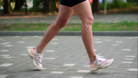 Female-athlete's-feet-running-at-the-park.-Fitness-woman-jogging-outdoors.-Exercising-on-park-pavement.-Healthy,-fitness