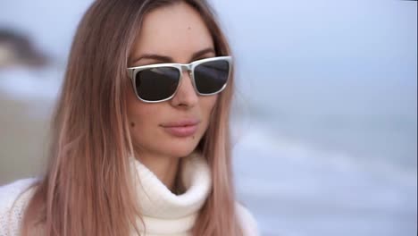 Calm-woman-standing-on-the-beach,-sea-waves-reflected-in-the-sunglasses