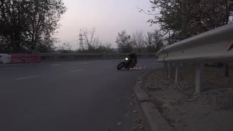 Brutal-man-riding-on-a-motorcycle-on-a-turn-clings-to-the-asphalt,-sparks-fly